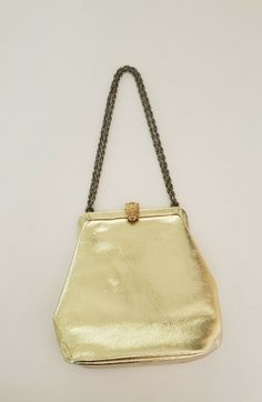 Listing is for a Vintage Wearwell Faux Metallic Gold Evening Bag with a Chain shoulder Strap and clasp closure. Bag measures 7" wide at largest point and 7" tall. Strap can be doubled or used as a single shoulder strap. This item is in excellent preowned condition. Appears unused on the inside. See photos. Shipped USPS Priority Mail. Leather Shoulder Bag With Gold Chain For Party, Evening Satchel Shoulder Bag With Chain, Formal Crossbody Bag With Chain Detail, Formal Chain Crossbody Bag, Leather Clutch Bag With Gold Chain, Leather Clutch With Gold Chain, Evening Crossbody Bag With Gold Chain, Classic Gold Satchel For Evening, Formal Clutch Bag With Chain