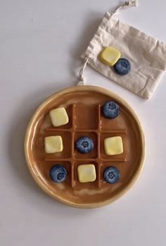 a plate with blueberries and marshmallows on it next to a napkin