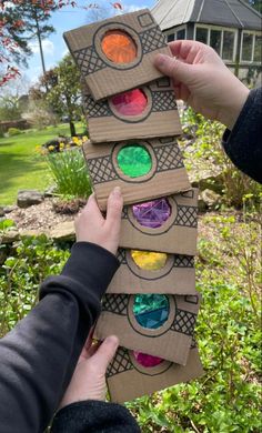 someone is holding up some paper plates with different colored lights on them