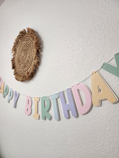 a happy birthday banner hanging on the wall next to a wooden slice and a piece of wood