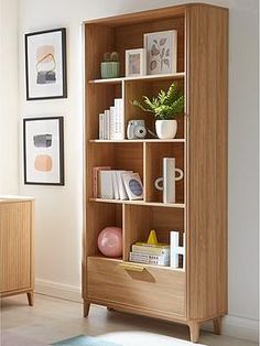 a wooden bookcase with books and pictures on it