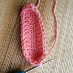 the crochet hook is being used to make an ear warmer