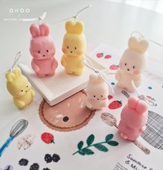 some little toy animals are sitting on top of a piece of paper with string attached to them