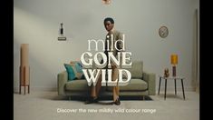 a woman sitting on top of a couch in front of a wall with the words mild gone wild