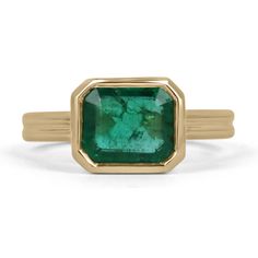 Displayed is a stunning East-to-West emerald solitaire engagement or right-hand ring in 18K yellow gold. This gorgeous solitaire ring carries a 2.75-carat emerald in a bezel setting. Fully faceted, this gemstone showcases excellent shine and beautiful, mossy medium green color. The emerald has very good clarity with minor flaws that are normal in all genuine emeralds! An ideal solitaire, perfect for everyday use!  Setting Style: Bezel Setting Material: 18K Yellow Gold         Setting Weight: 6.3 Emerald Bezel Ring, Emerald Anniversary, Mossy Green, Split Shank Ring, Solitaire Setting, Bezel Ring, Ring Emerald, Zambian Emerald, Right Hand Rings