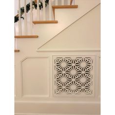 a white stair case next to a banister and some stairs with christmas decorations on it