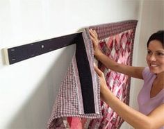 a woman is hanging clothes on a rack