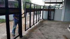 a man standing next to a metal fence