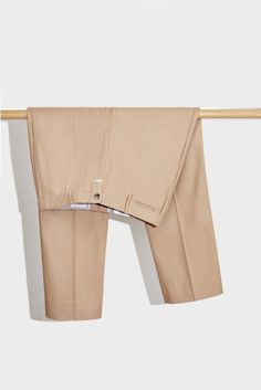 a pair of beige pants hanging on a clothes line with the bottom section folded down