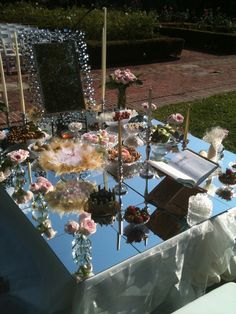 the table is covered with flowers and cake for an outdoor wedding or special event venue