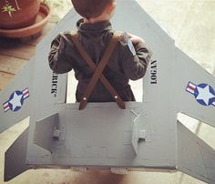 a young boy sitting on top of a toy plane