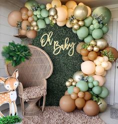 a baby shower is decorated with balloons and greenery