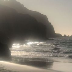 the sun shines through the foggy water at the beach