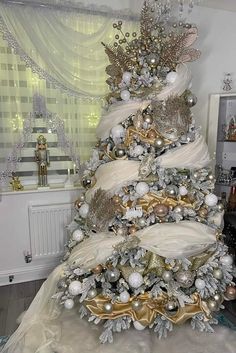 a white christmas tree with gold and silver decorations