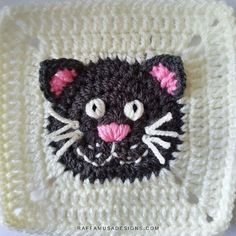 a crocheted square with a cat face on it