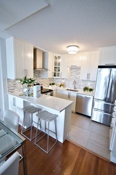 a kitchen with white cabinets and stainless steel appliances