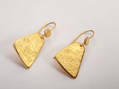 Hammered triangle drop earrings in bohemian style. Lightweight and perfect for everyday wear.  A unique and original form to bring personality and a little sparkle to your ears!  Perfect as a gift for yourself or for a loved one!  Specifications: ◈ Each triangle is 10-16mm (0.39-0.62 inches) in diameter ◈ Each earring measures 16mm (0.62 inches) wide by 35mm (1.37 inches) long.  ◈ Weight: about 5g  ◈ Material: Solid 14k gold  ◈ Nickel free. ◈ All earrings with French ear wires come with silicon backings for extra protection. In case of custom orders - please contact us for pricing. ◈ SHIPPING is insured express and free worldwide ◈ GIFT WRAPPING is included with every purchase ✧ Looking for more unique and beautiful wedding bands: https://etsy.me/32OIpT5  ✧ Back to my shop for more handcra Bohemian Gold Triangle Jewelry, Triangle Yellow Gold Earrings For Gift, Handmade Gold Triangle Jewelry, Gold Triangle Jewelry With Ear Wire, Gold Schmuck, Beautiful Wedding Bands, Gold Triangle, Gold Earrings For Women, Hammered Gold