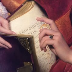 a painting of two hands holding a book and a ring on top of the book