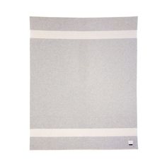 a gray and white blanket with two horizontal stripes on the bottom, in front of a white background