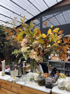 a table topped with lots of vases filled with different types of flowers and plants