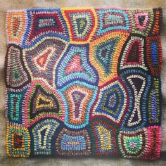 a colorful piece of art that is made out of beaded thread and yarns