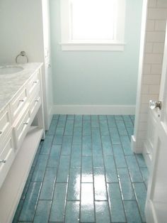 a bathroom with blue tile floors and white fixtures