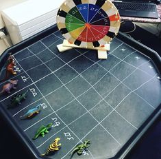 a game board with toy dinosaurs on it