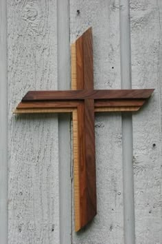 a wooden cross mounted to the side of a building