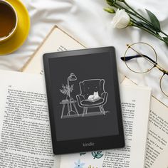 an open book sitting on top of a table next to a cup of coffee and glasses