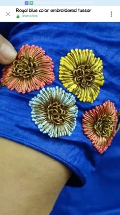 a woman is showing off her colorful flowered bracelet on her arm and the other hand