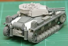 a small toy tank sitting on top of a green table next to a black and white object