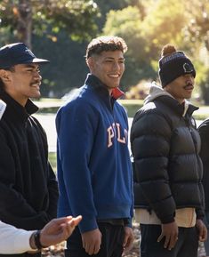 three men standing next to each other talking