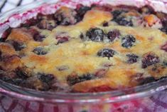 a close up of a pie in a glass dish on a stove top with blueberries and other toppings