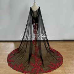 a black and red dress with flowers on the skirt is displayed in front of a white wall