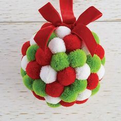 a christmas ornament with red, white and green pom - poms