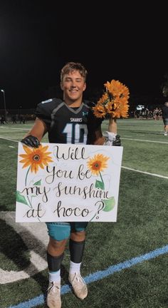 a young man holding a sign that says, will you be my sunshine at hope?