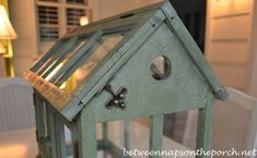 a green birdhouse sitting on top of a table