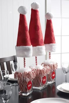 some candy canes and santa hats on top of each other at a dining room table