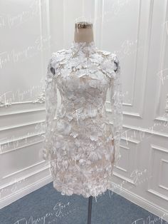 a white dress on display in front of a wall