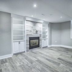 empty living room with fireplace and built - in bookcases