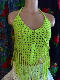 a mannequin wearing a green crochet top with fringes on it