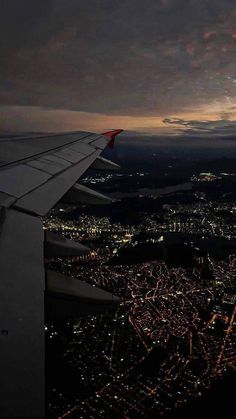 an airplane wing flying over a city at night