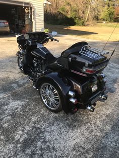 a black motorcycle parked in front of a garage