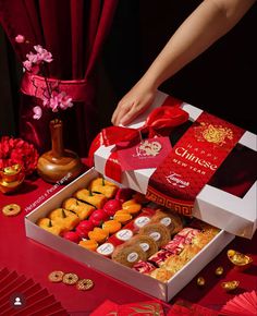 a person opening a box of chinese sweets