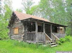 an old log cabin sits in the woods