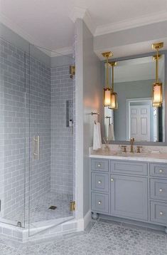 a bathroom with gray and gold fixtures, marble counter tops and white tile flooring