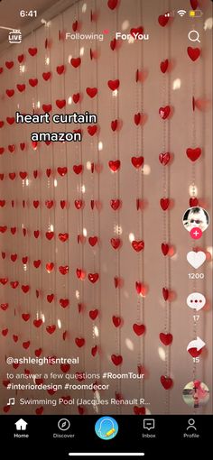 the heart curtain is hanging from the ceiling with red hearts attached to it's sides