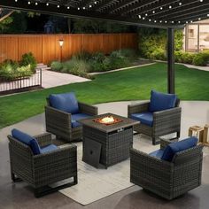 an outdoor fire pit with blue cushions and chairs around it in front of a backyard