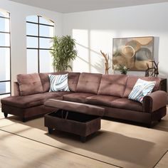 a living room with a sectional couch and footstool in front of large windows