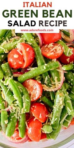 green bean salad with tomatoes and onions in a glass bowl on top of a white table